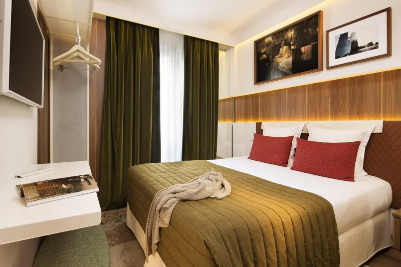 Hôtel Eiffel Turenne – Chambre, couvre-lit olive et coussins rouges