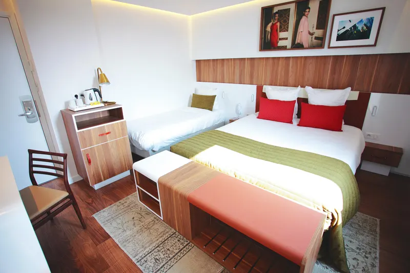 Hôtel Eiffel Turenne – Chambre double, couvre-lit vert et tête de lit en bois