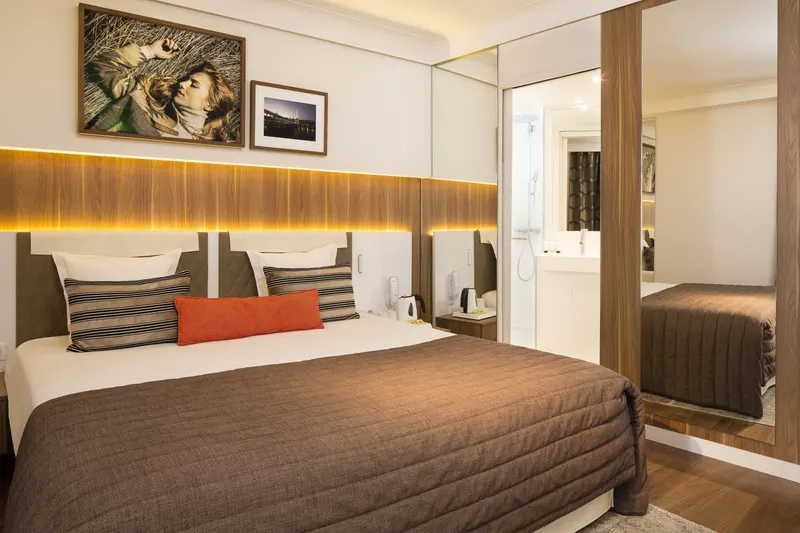 Hôtel Eiffel Turenne – Chambre, couvre-lit brun et photographies