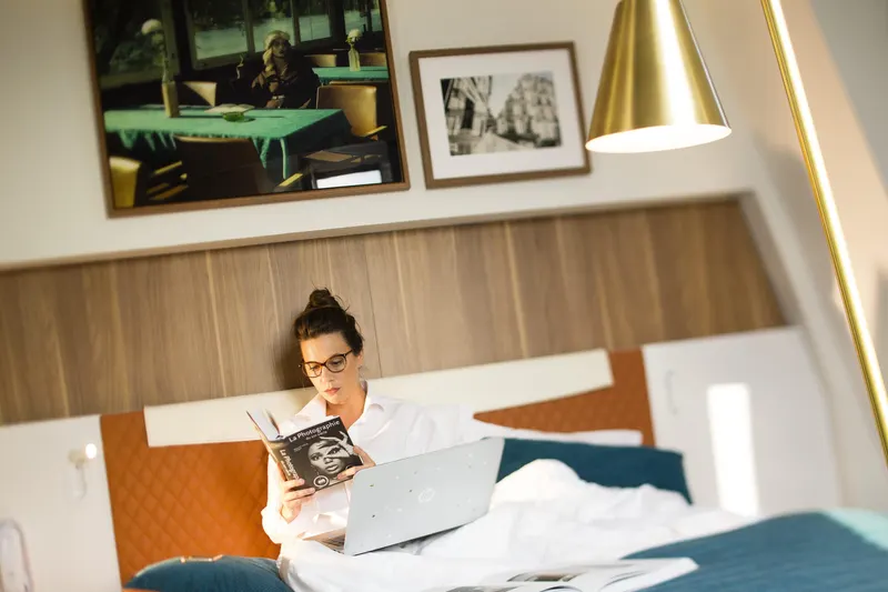 Hôtel Eiffel Turenne – Cliente lisant sur le lit