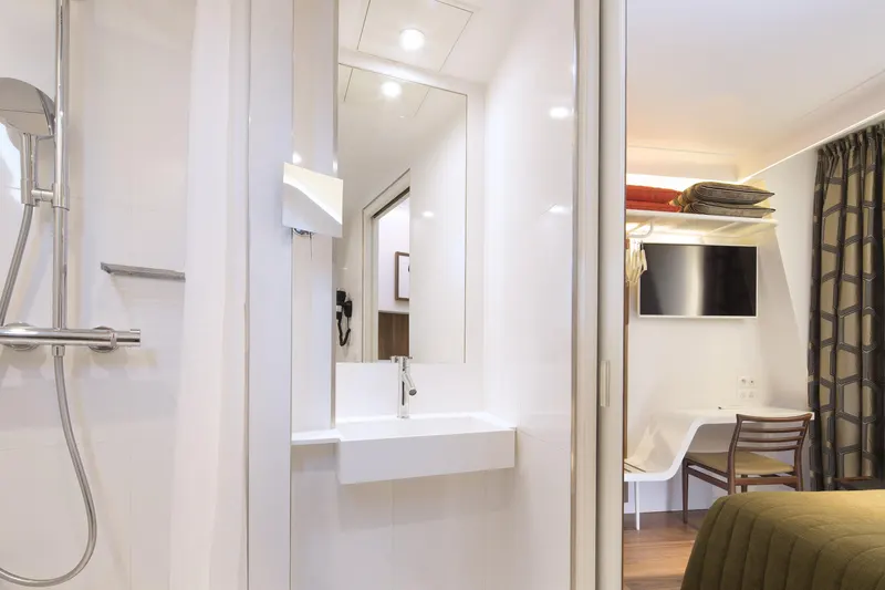 Hôtel Eiffel Turenne – Salle de bain blanche, douche et lavabo