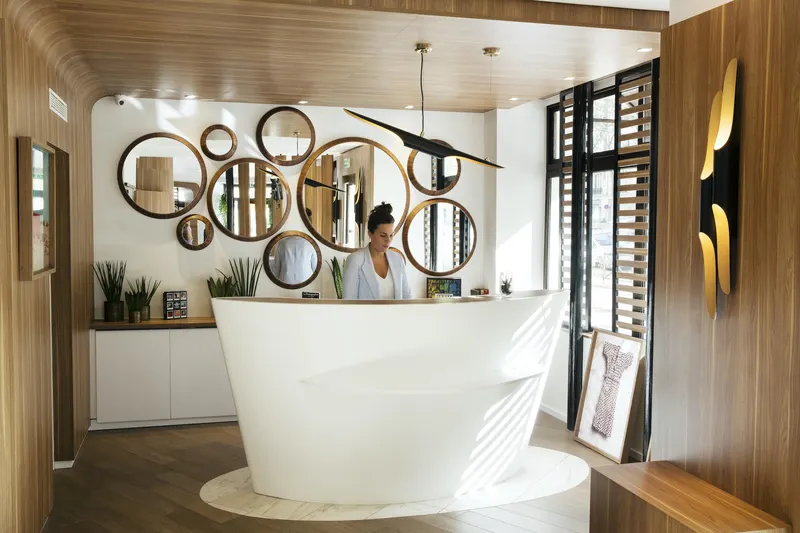 Hôtel Eiffel Turenne – Réception, miroirs ronds et comptoir blanc