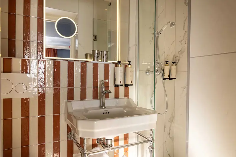 Grand Hôtel de Turin – Salle de bain rayée rouge et blanc, lavabo sur pieds