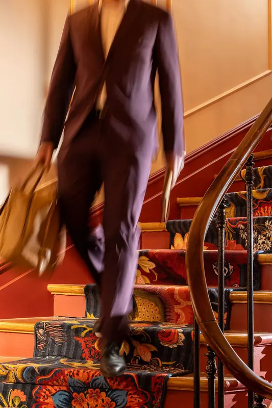Grand Hôtel de Turin – Homme en costume dans l’escalier à tapis fleuri